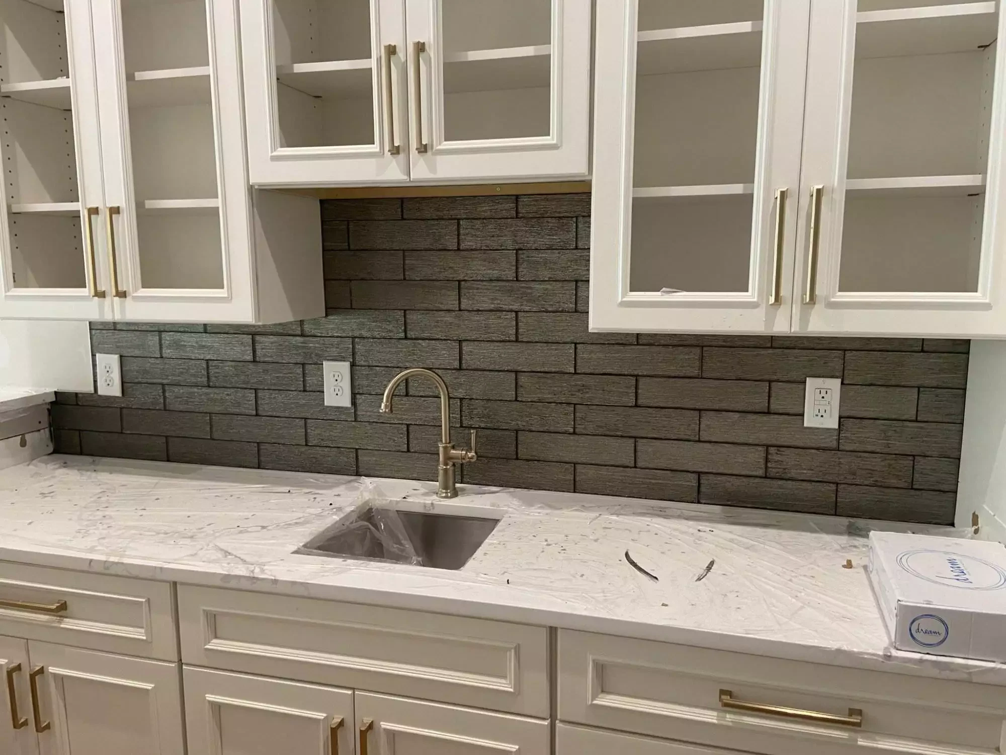 Modern kitchen with white cabinets and dark backsplash