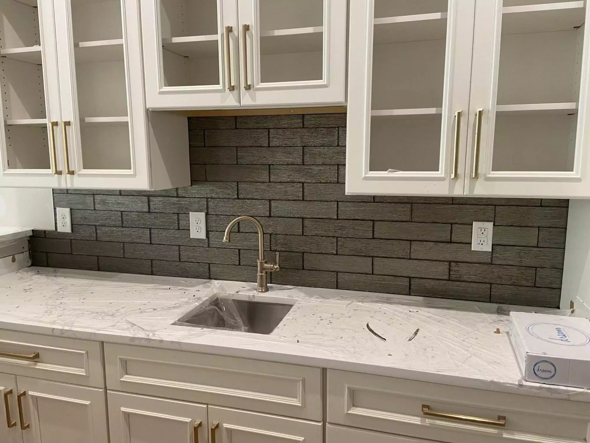 Modern kitchen with white cabinets and dark backsplash