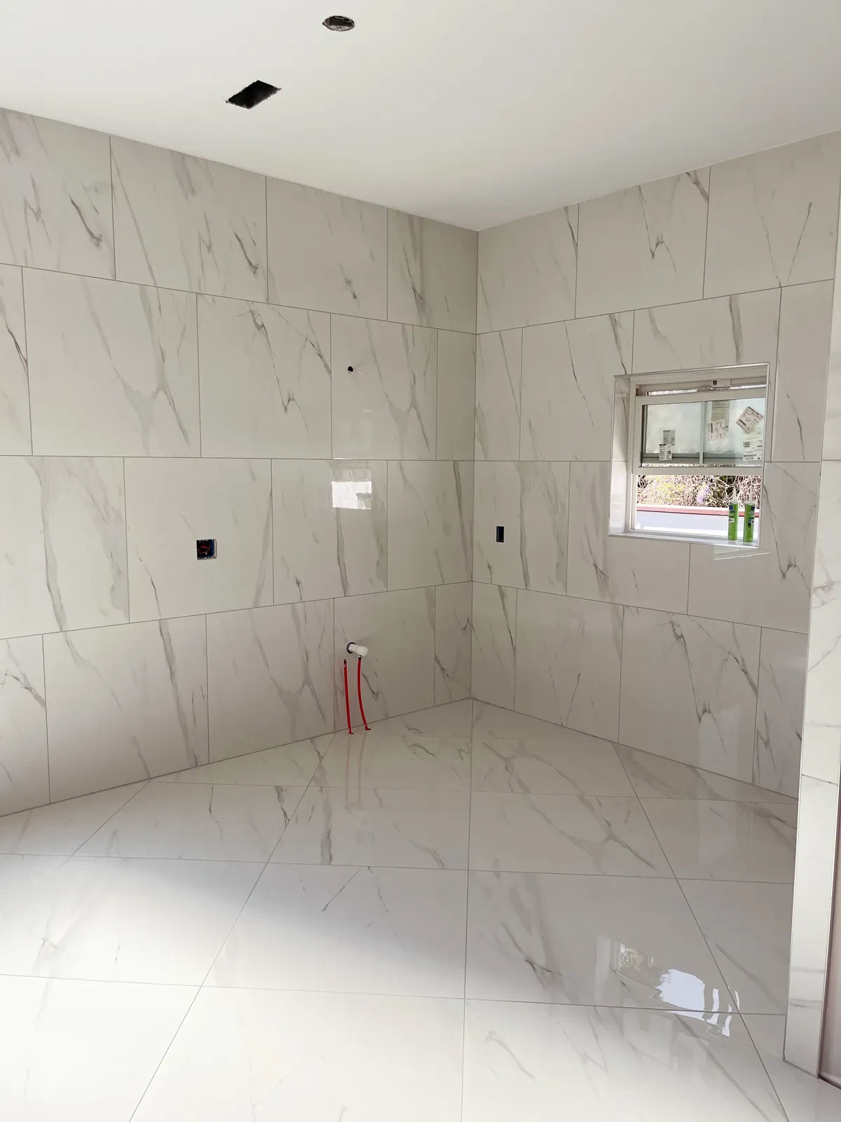 Shiny marble-tiled bathroom under construction