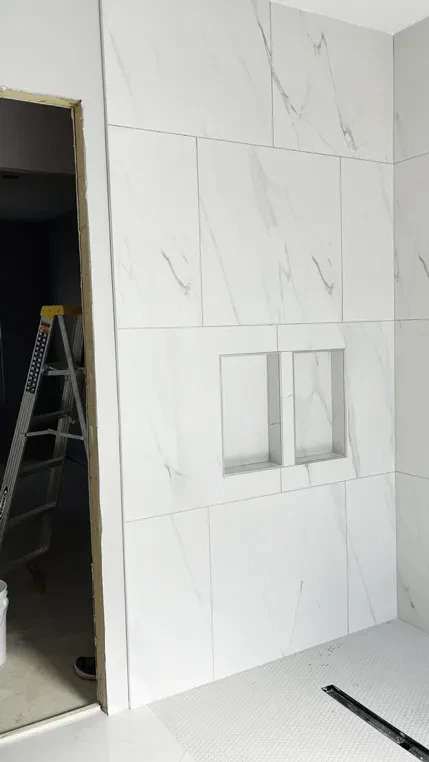 Modern bathroom tile installation with ladder