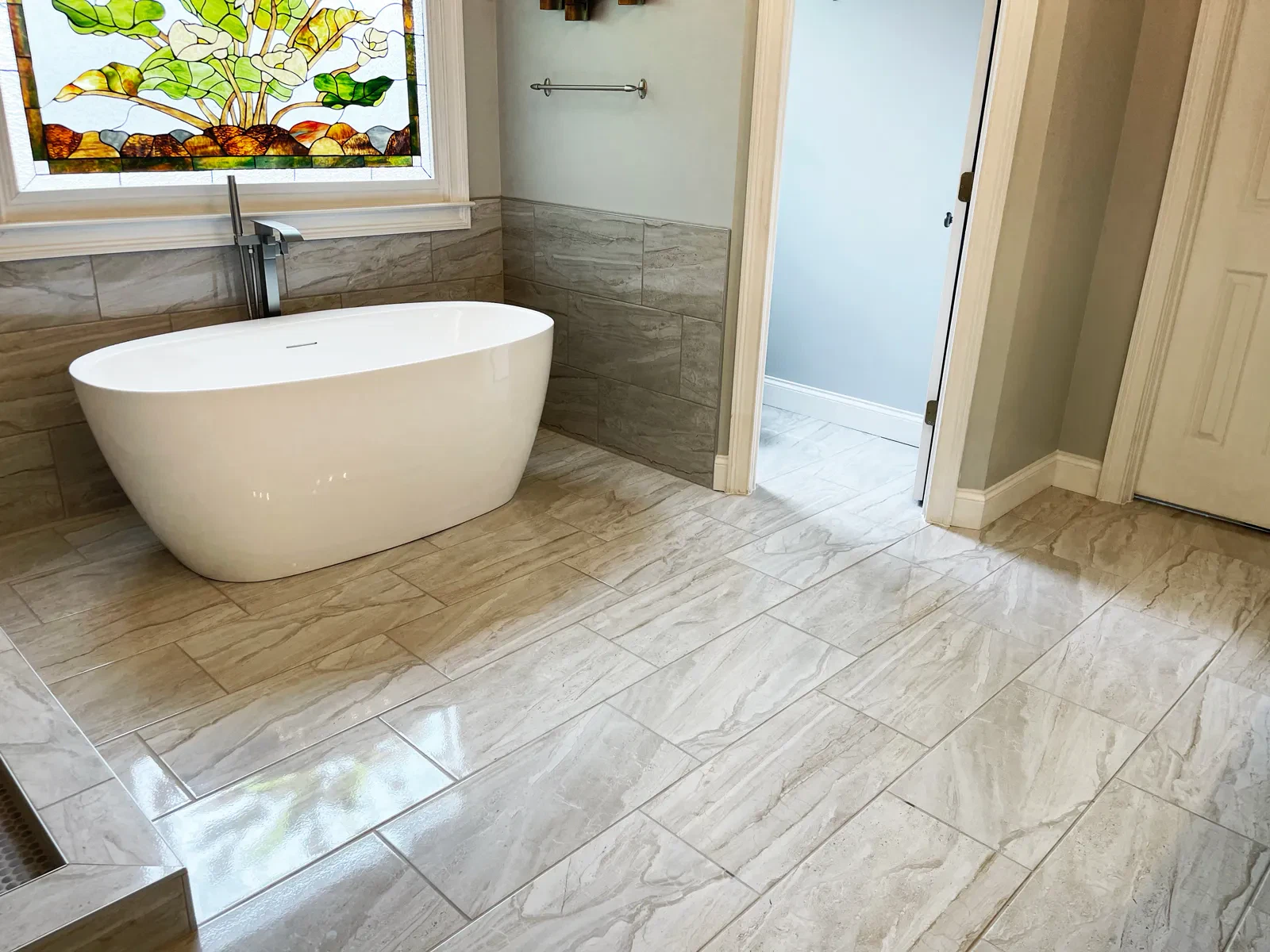 Modern bathroom with standalone tub and stained-glass window