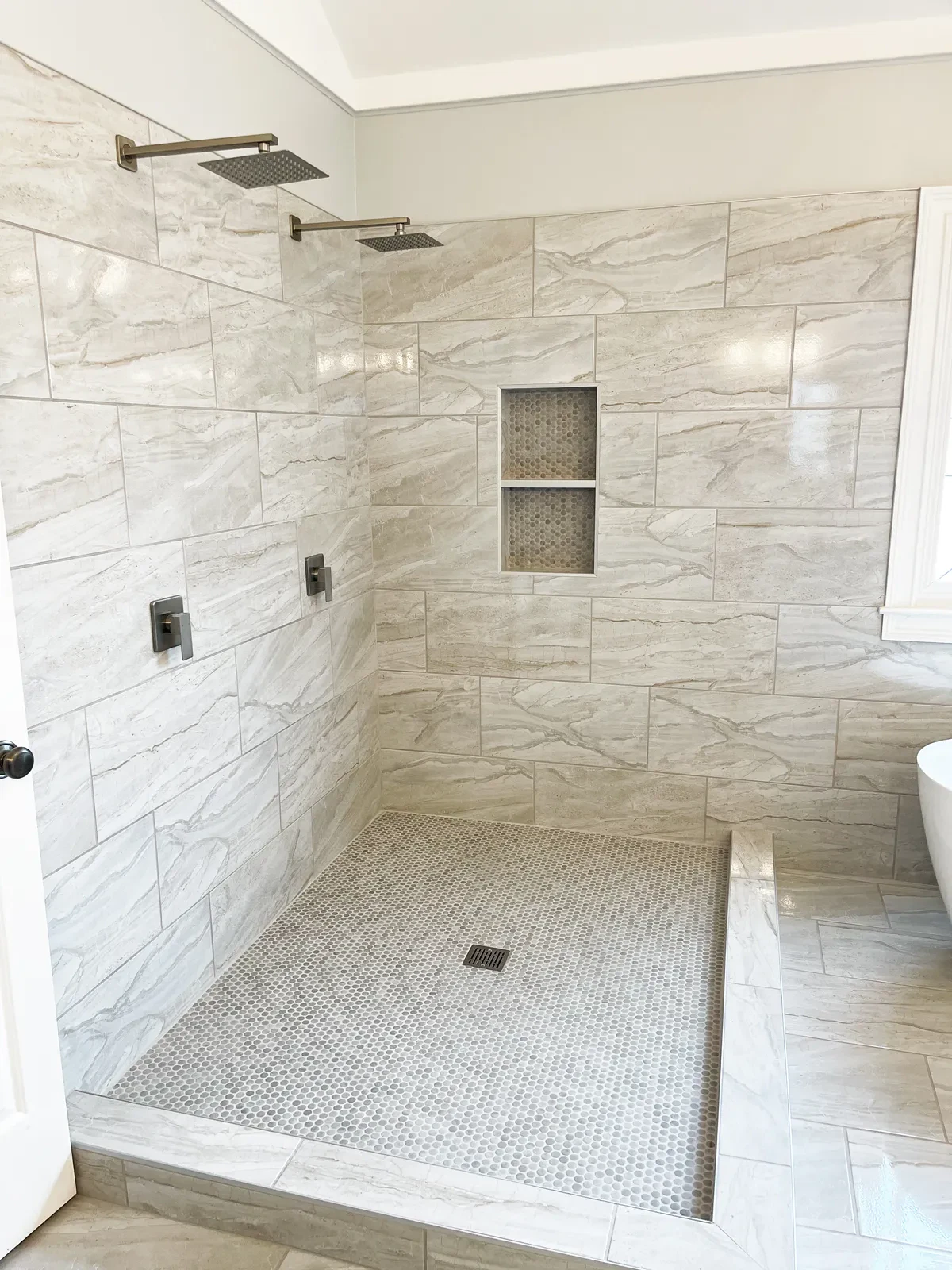 Modern marble tiled shower with dual showerheads