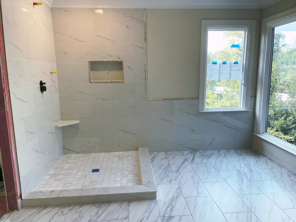 Spacious bathroom with large marble-tiled shower area