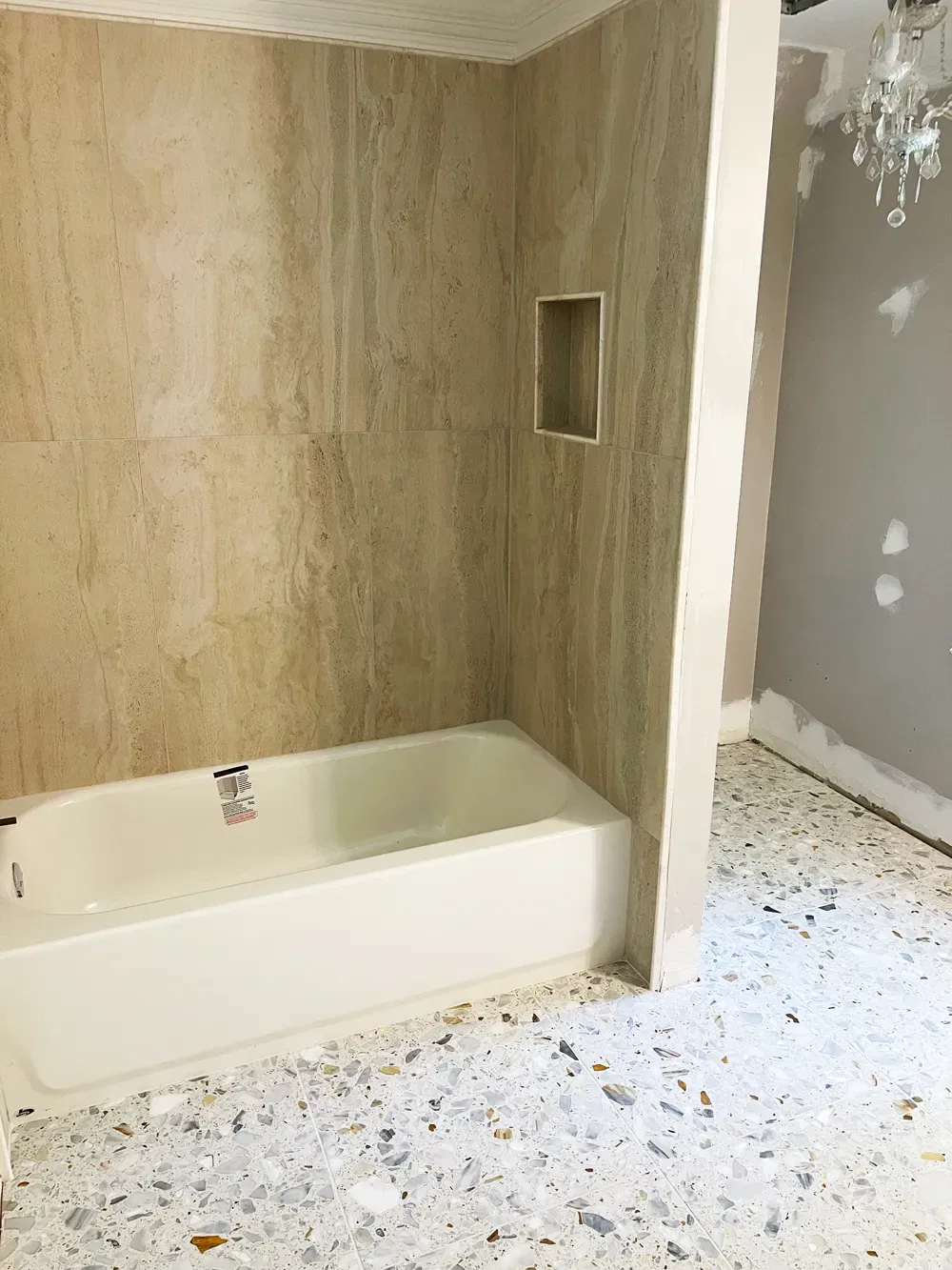 Unfinished bathroom with new bathtub and terrazzo flooring