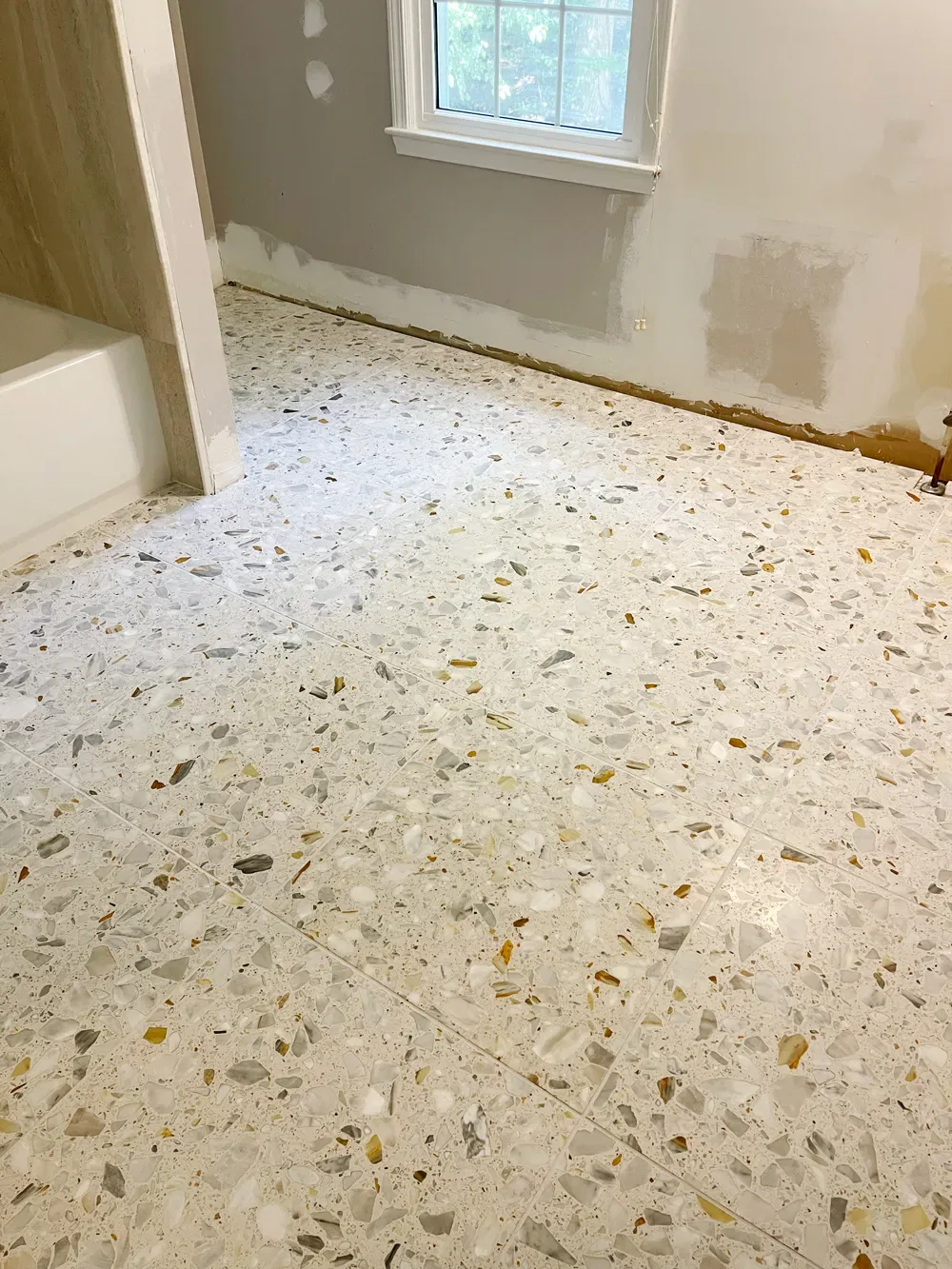 Renovated room with terrazzo flooring and primed walls