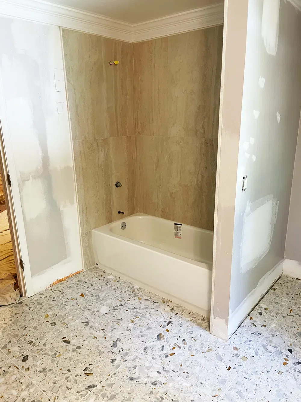 Unfinished bathroom remodel with exposed walls and tub