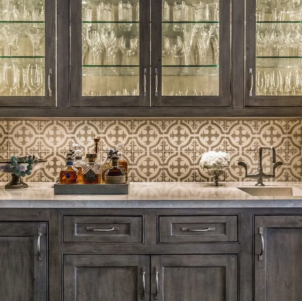 Elegant kitchen bar with decorative tile backsplash.
