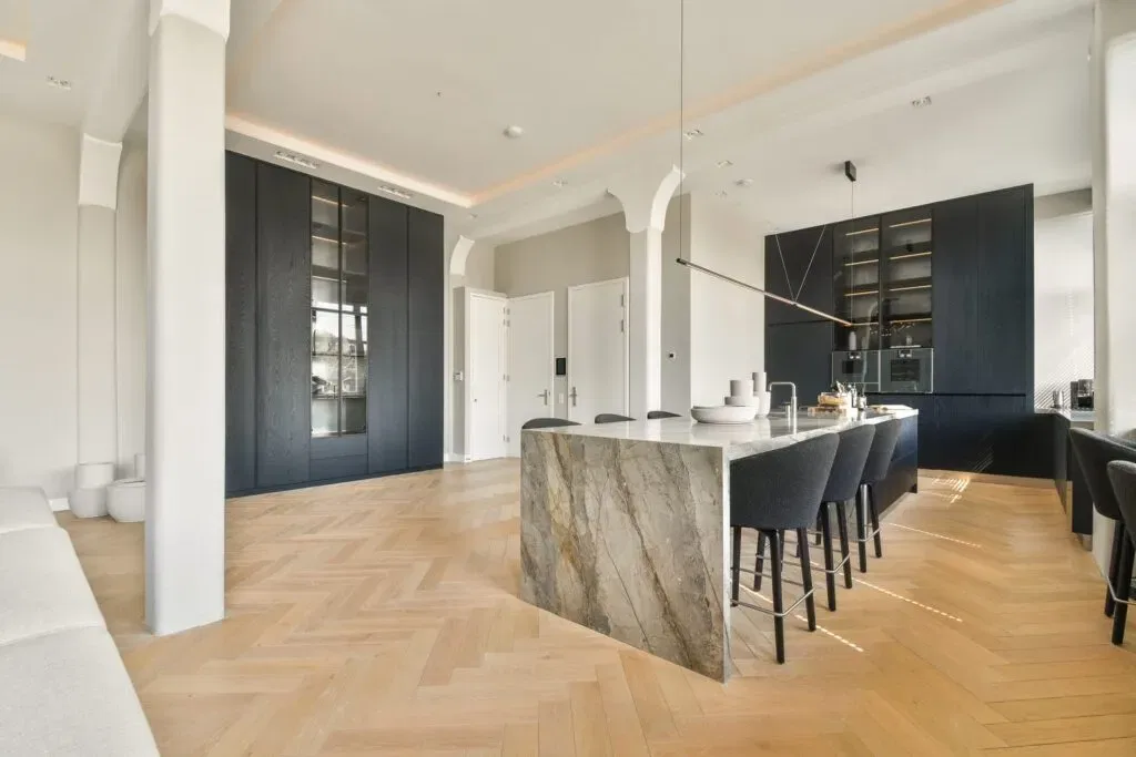 Modern kitchen with marble island and herringbone floor
