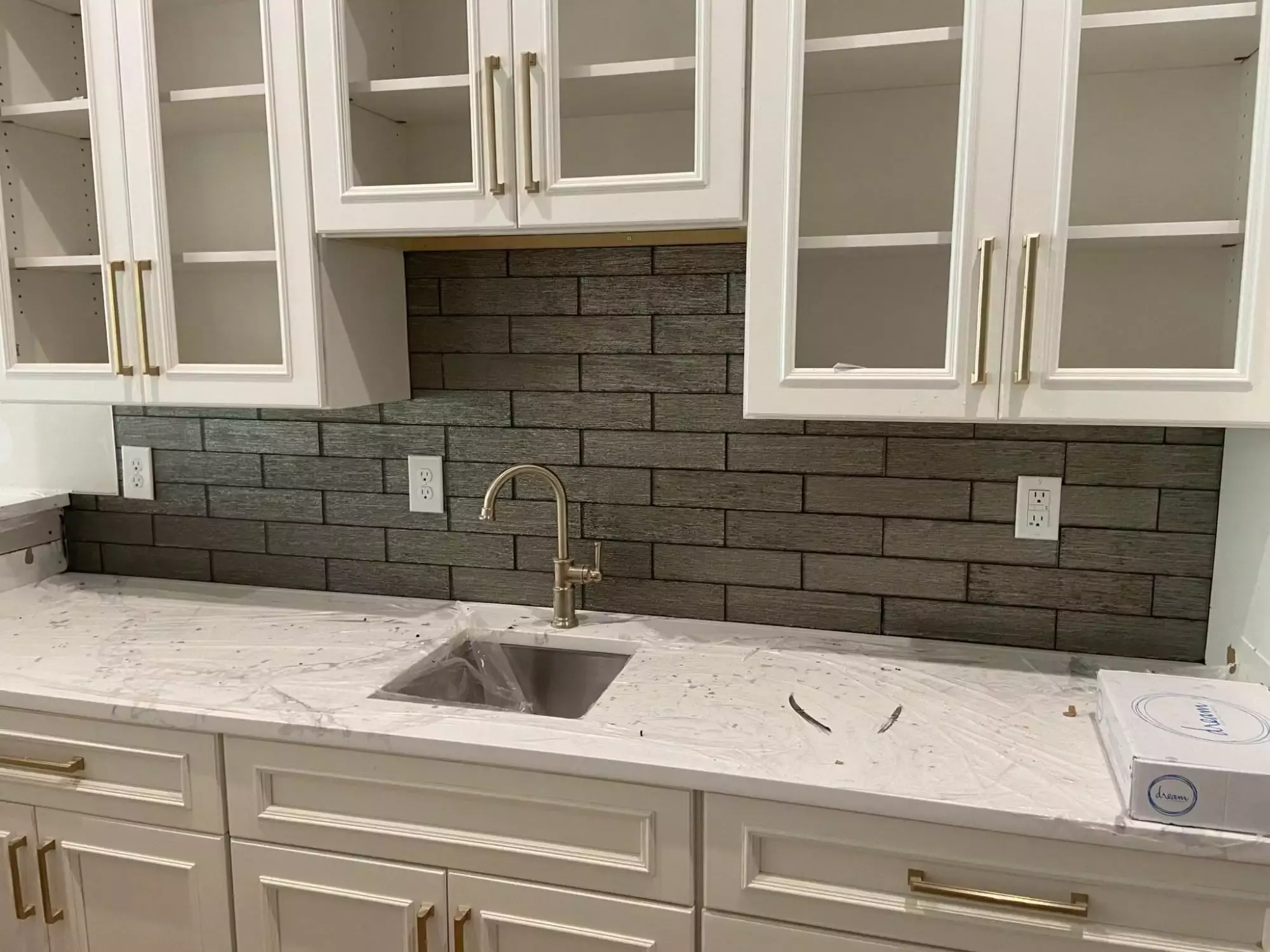 Modern kitchen with white cabinets and dark backsplash