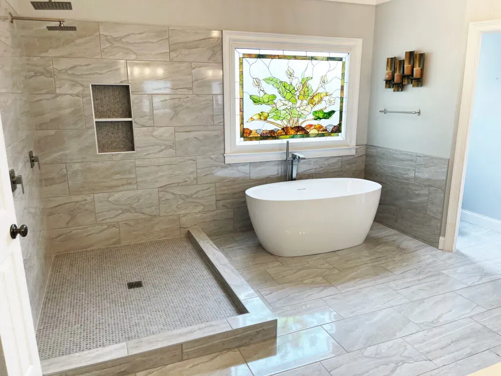 Modern bathroom with freestanding tub and stained glass window