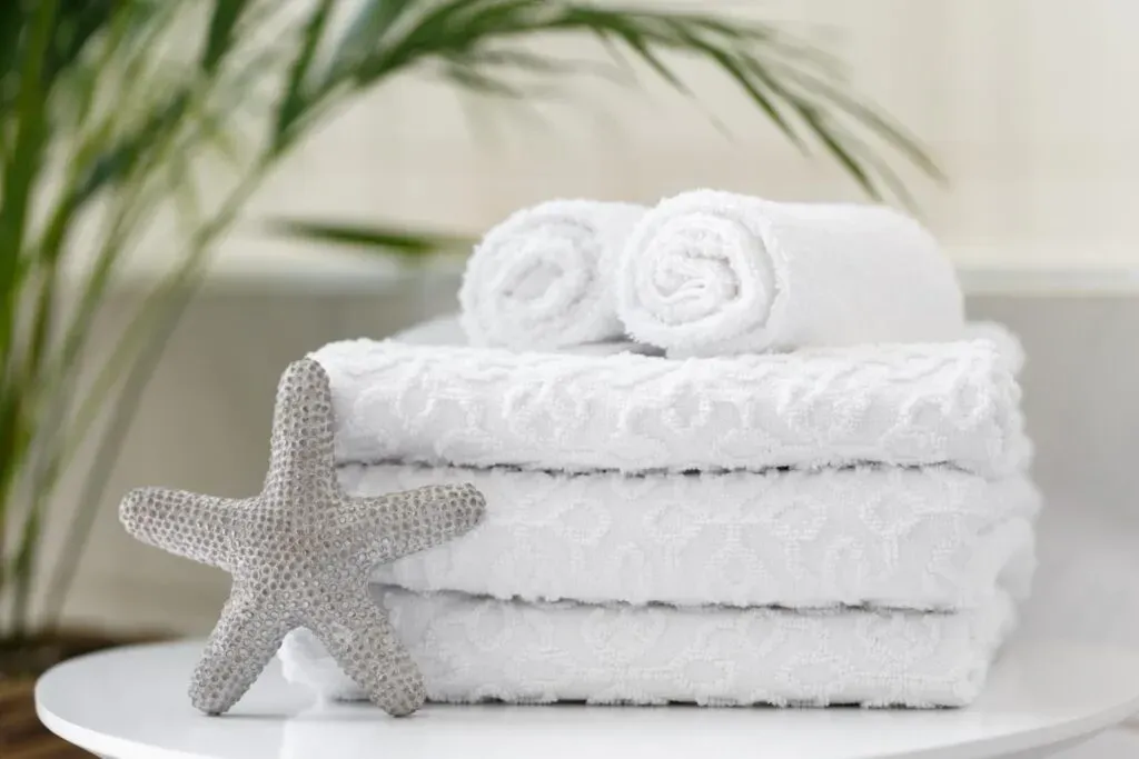 White embroidered towels and starfish on plate spa concept