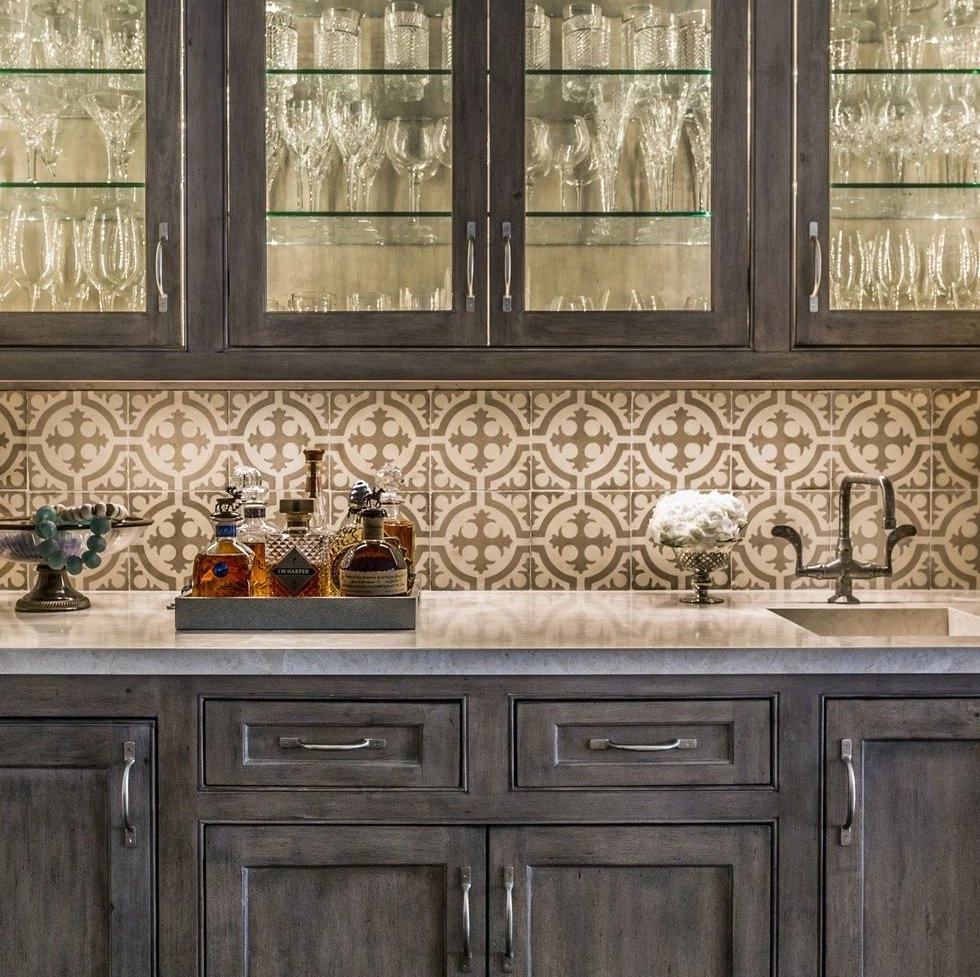 Elegant kitchen bar with decorative tile backsplash.