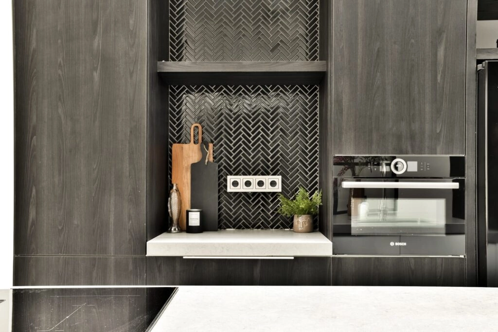 Modern kitchen nook with dark cabinetry and herringbone backsplash