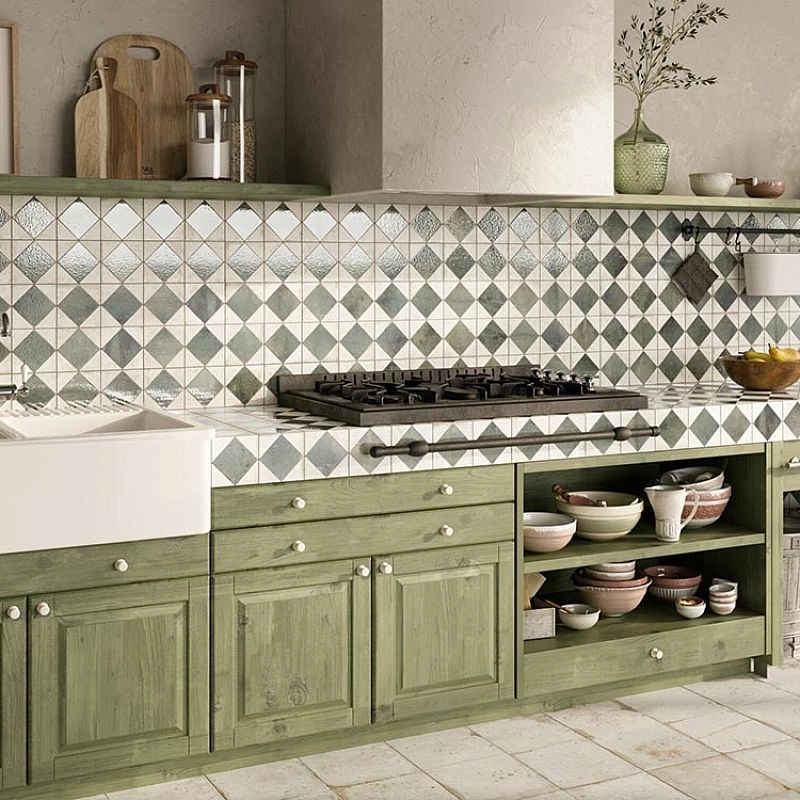 Green kitchen cabinets with geometric backsplash tiles